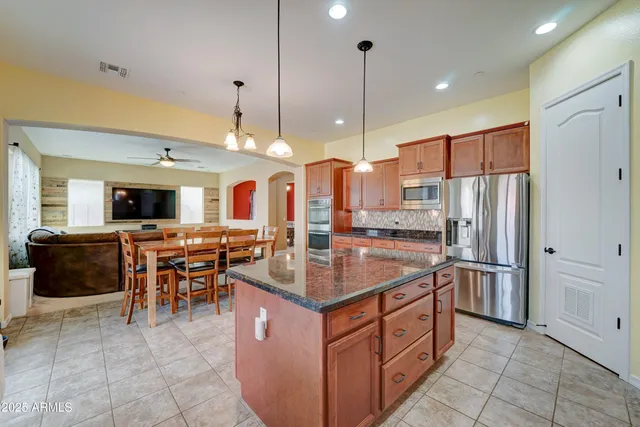 a kitchen with stainless steel appliances granite countertop a refrigerator a sink and a stove