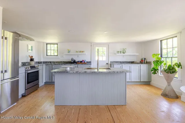 a kitchen with kitchen island a sink wooden floor and counter top space