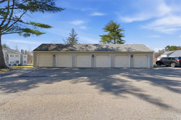 a view of a white house with a yard and a large tree