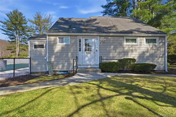 a view of house with yard and outdoor seating