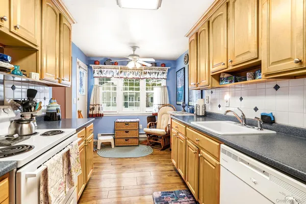 a kitchen with kitchen island granite countertop a sink stove and cabinets
