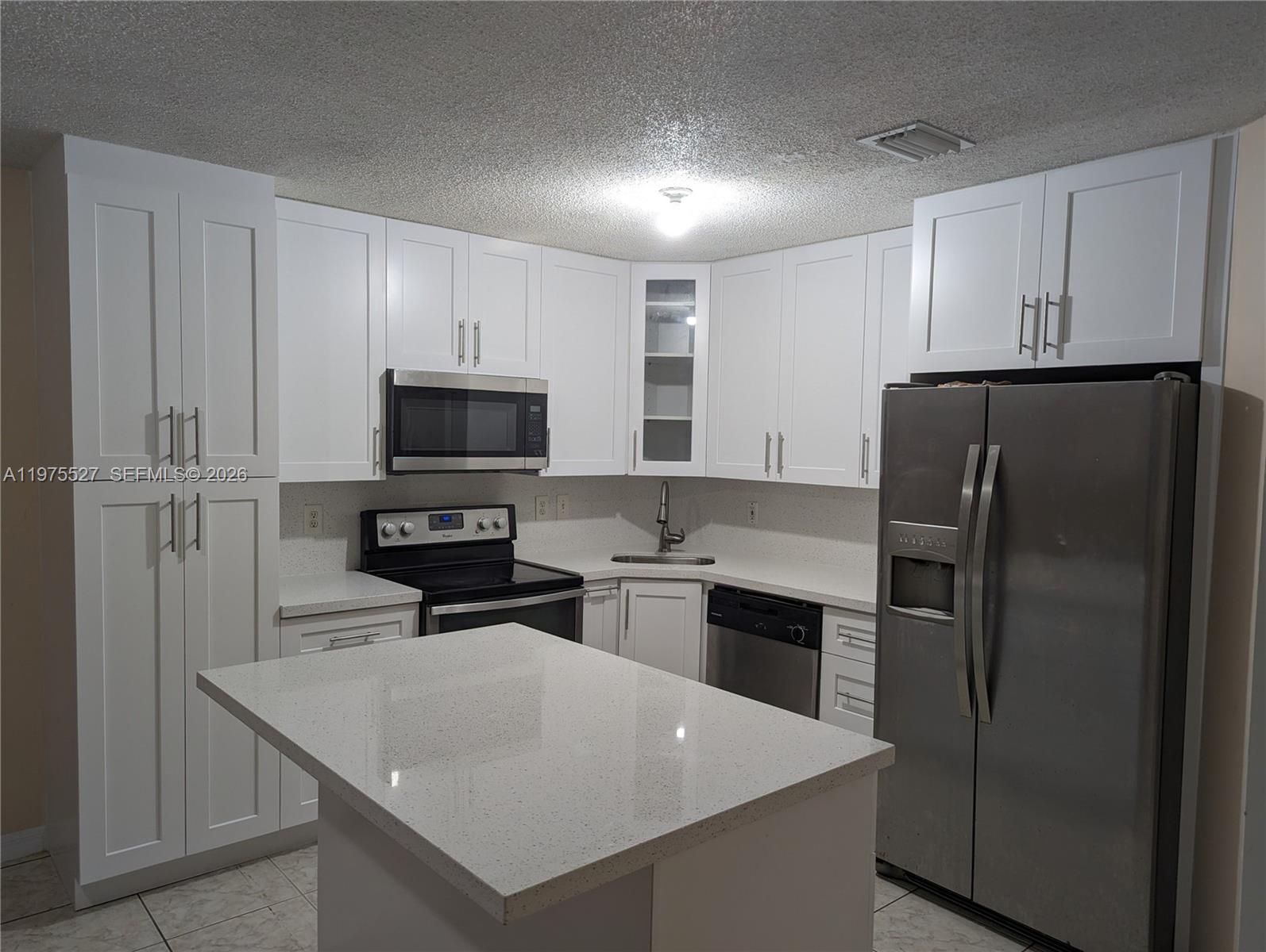 8719 Southwest 158th Path Miami, FL 33193 - Photo 5 of 13 a kitchen with a refrigerator stove and microwave