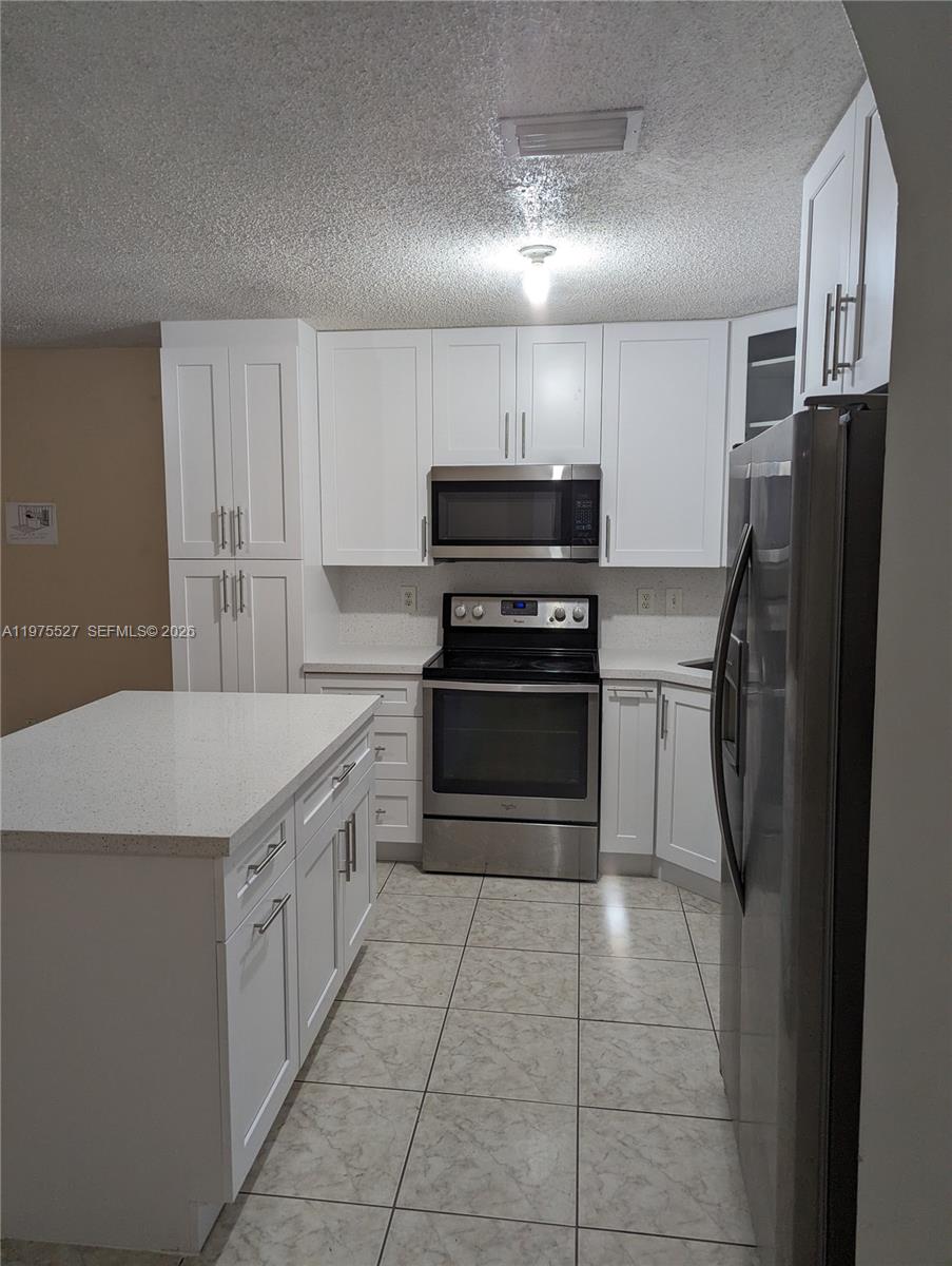 8719 Southwest 158th Path Miami, FL 33193 - Photo 6 of 13 a kitchen with stainless steel appliances granite countertop a refrigerator and a stove top oven