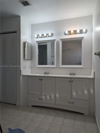 a bathroom with a sink vanity and mirror