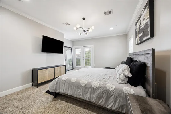 a bedroom with a bed and a flat tv screen on wall