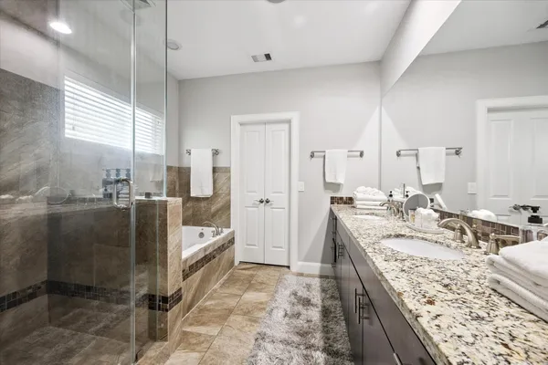 a large bathroom with double vanity and a bathtub