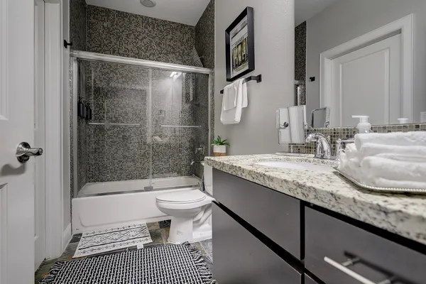 a bathroom with a sink a toilet and shower