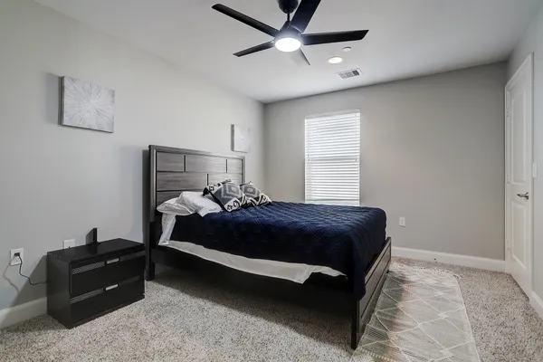 a bedroom with a bed window and a ceiling fan