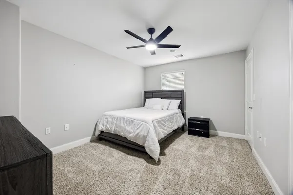 a bedroom with a bed and a ceiling fan