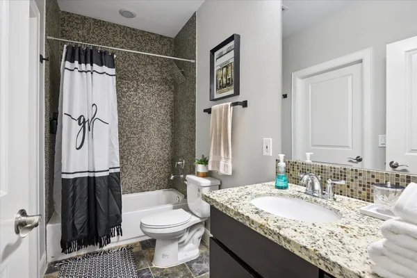 a bathroom with a granite countertop sink toilet and shower
