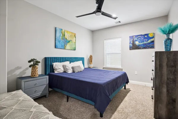 a bedroom with a bed and a painting on the wall