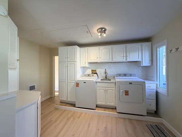 a kitchen with white cabinets and stainless steel appliances