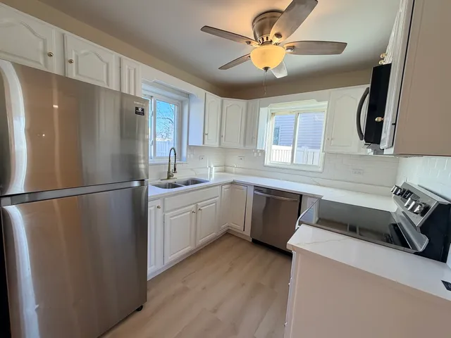 a kitchen with a refrigerator sink and cabinets