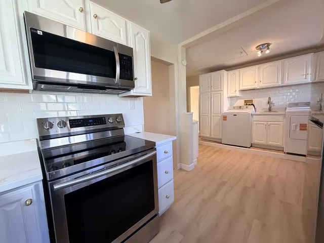 a room with window and white cabinets