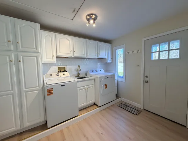 a kitchen with cabinets appliances and a wooden floor