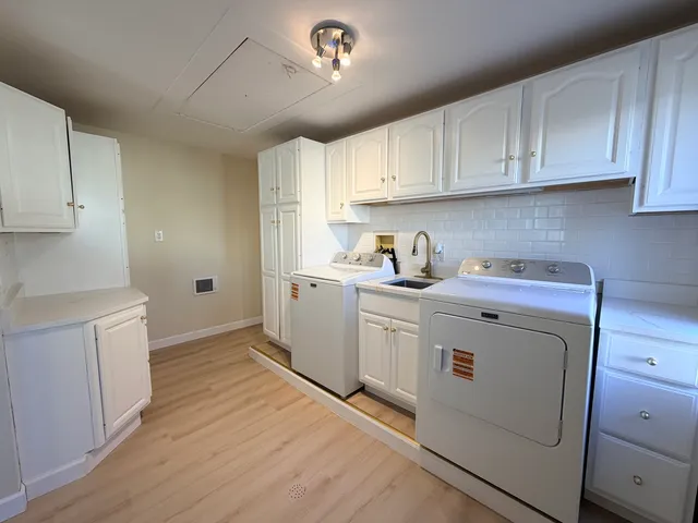 a utility room with cabinets washer and dryer