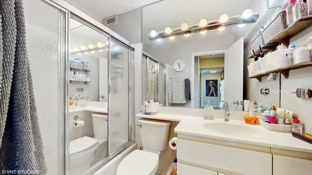 a bathroom with a sink mirror vanity and toilet