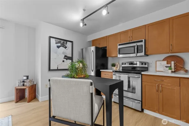 a kitchen with stainless steel appliances a stove refrigerator sink and microwave