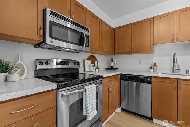 a kitchen with stainless steel appliances granite countertop a sink stove and microwave