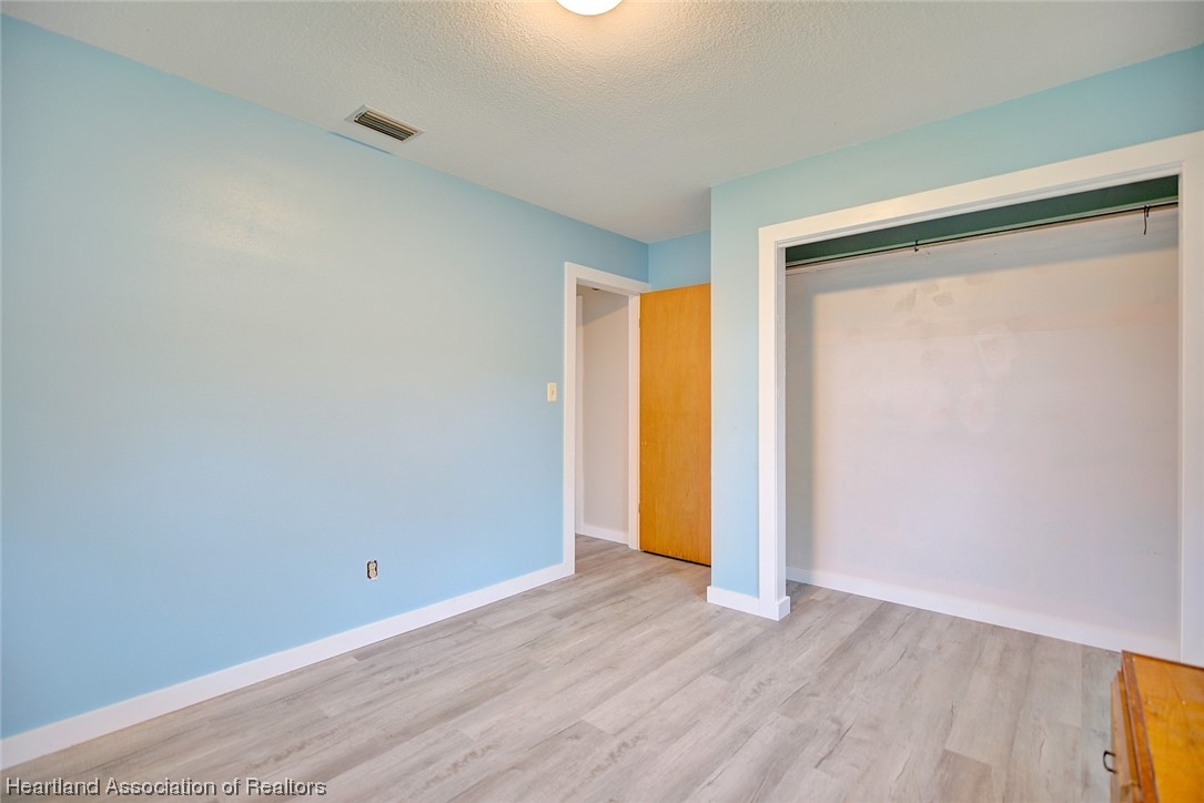 114 Spring Garden Road Sebring, FL 33870 - Photo 15 of 34 a view of an empty room with wooden floor and a window