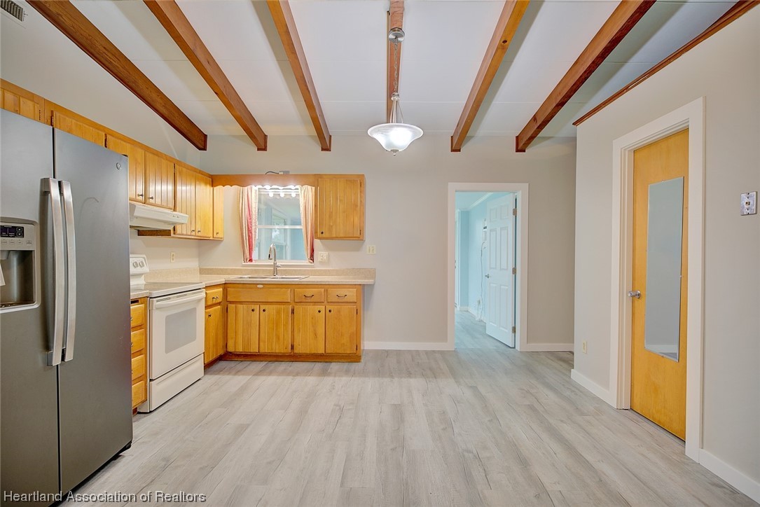 114 Spring Garden Road Sebring, FL 33870 - Photo 25 of 34 a kitchen with stainless steel appliances granite countertop a refrigerator a sink dishwasher a stove and white countertops with wooden floor