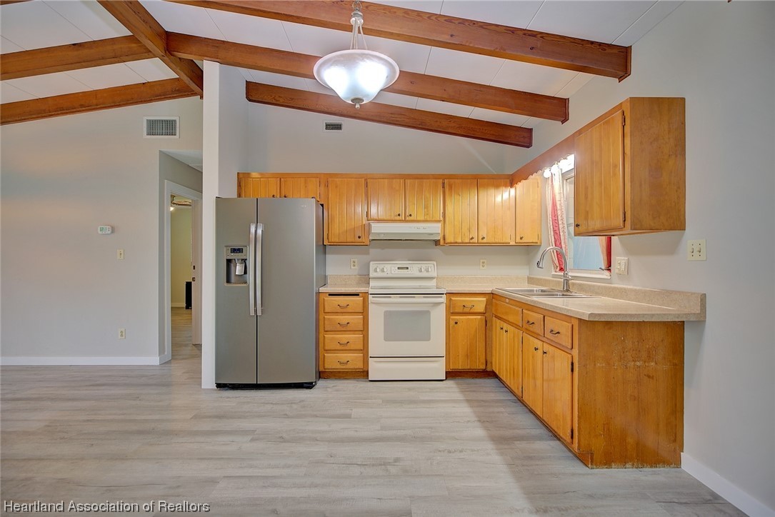114 Spring Garden Road Sebring, FL 33870 - Photo 7 of 34 a kitchen with stainless steel appliances granite countertop a refrigerator a sink dishwasher a stove with wooden cabinets and floor