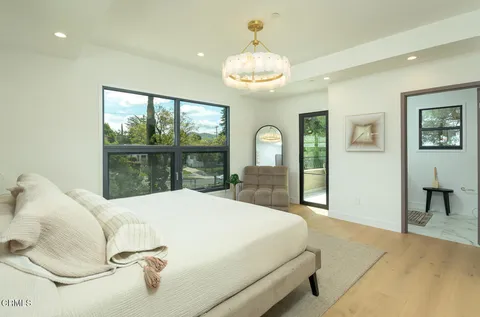 a bed sitting in a spacious bedroom next to a window