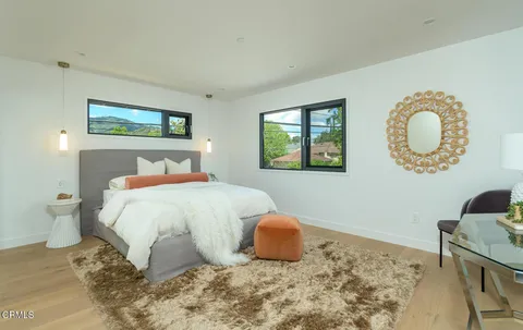 a bedroom with a bed and painting on the wall