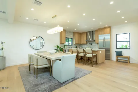 a large dining space with a large window and stainless steel appliances