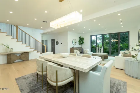 a dining hall with stainless steel appliances kitchen island a table and chairs