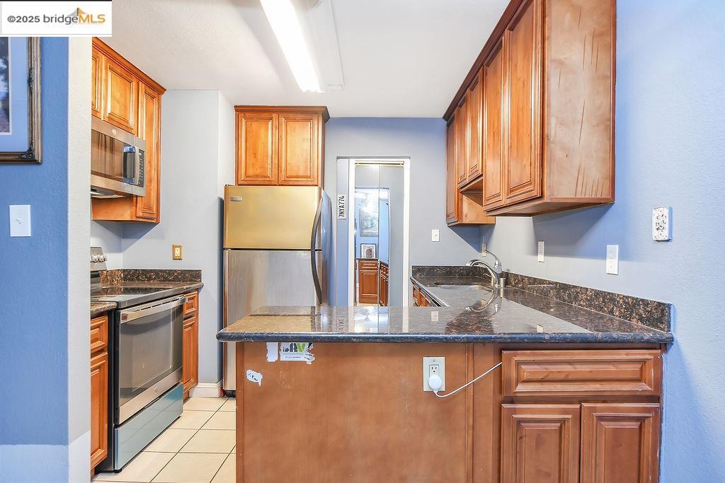 1699 Laguna Street, Unit 311 Concord, CA 94520 - Photo 12 of 29 a kitchen with stainless steel appliances granite countertop a stove a sink and a microwave