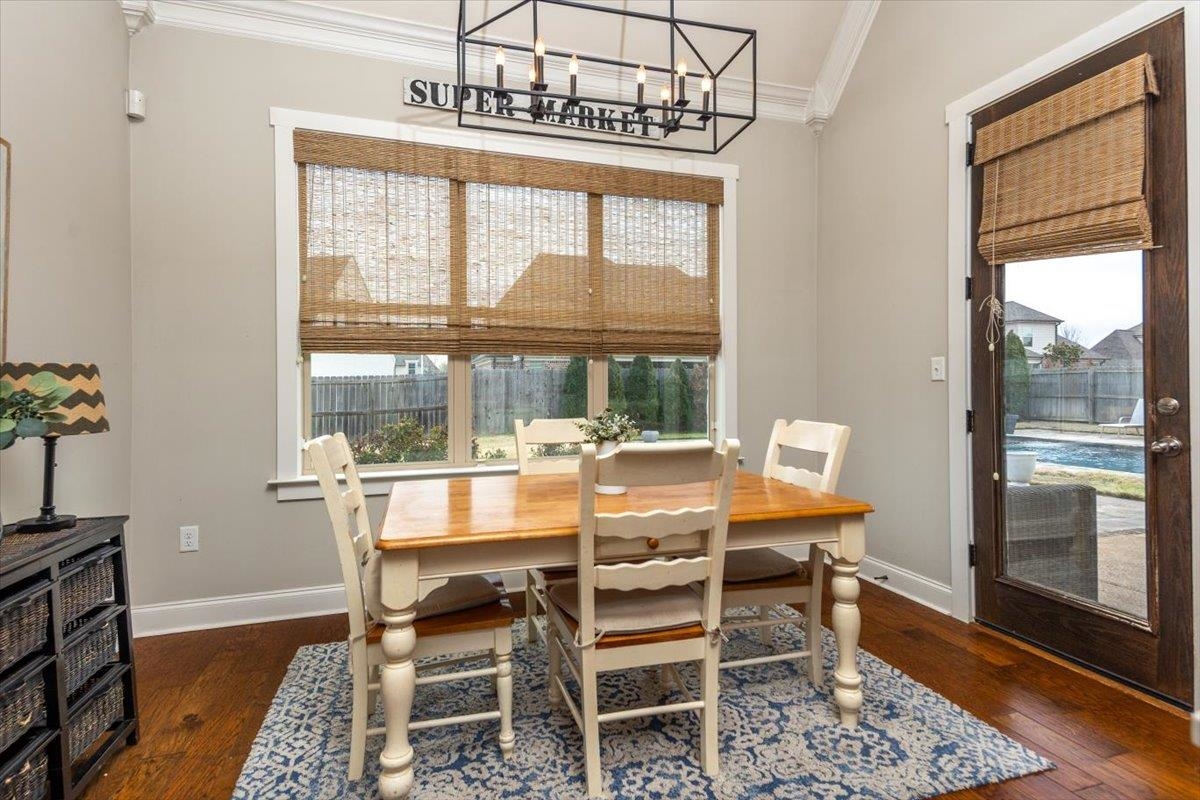 608 Cypress Run Cove Collierville, TN 38017 - Photo 15 of 40 Dining area with ornamental molding, dark wood finished floors, and a chandelier