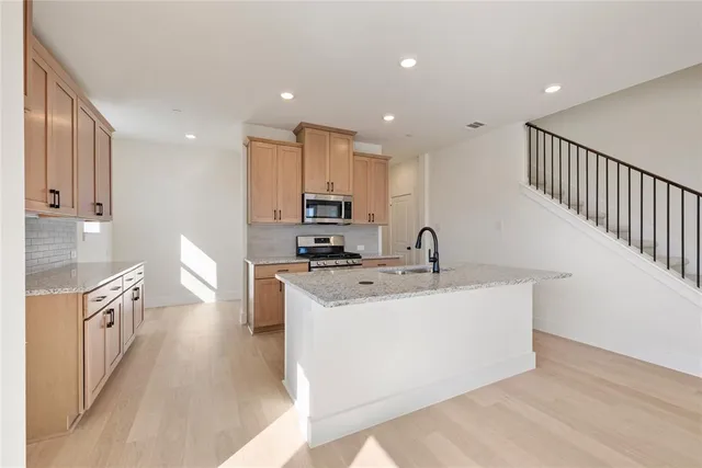 a view of a kitchen with kitchen island a sink a counter top space and cabinets