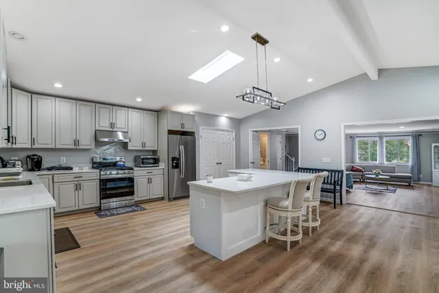 a large kitchen with kitchen island a island a stove a dining table and chairs