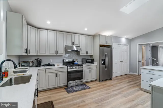 a kitchen with a sink stainless steel appliances and cabinets