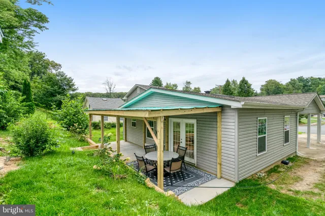 a view of a house with a yard and sitting area