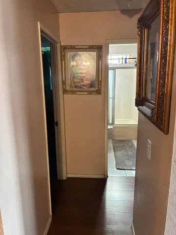 a view of a hallway with wooden floor