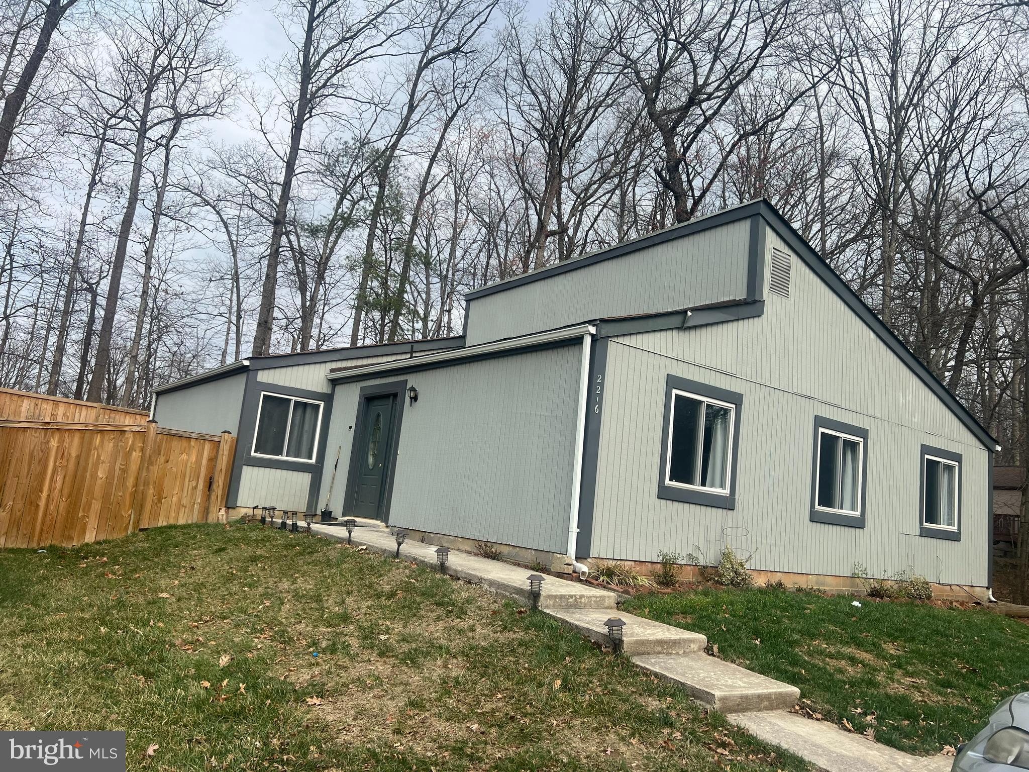 2216 Sanibel Drive Reston, VA 20191 - Photo 1 of 15 a backyard of a house with large trees and wooden fence