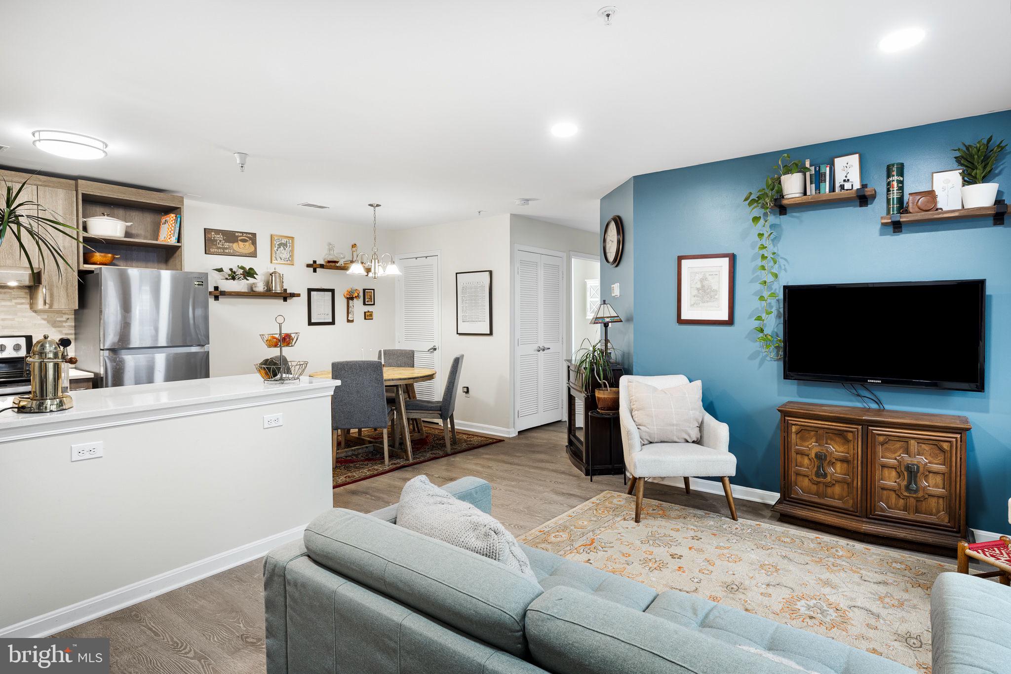 645 Constellation Square Southeast, Unit B Leesburg, VA 20175 - Photo 4 of 17 a living room with furniture and a flat screen tv