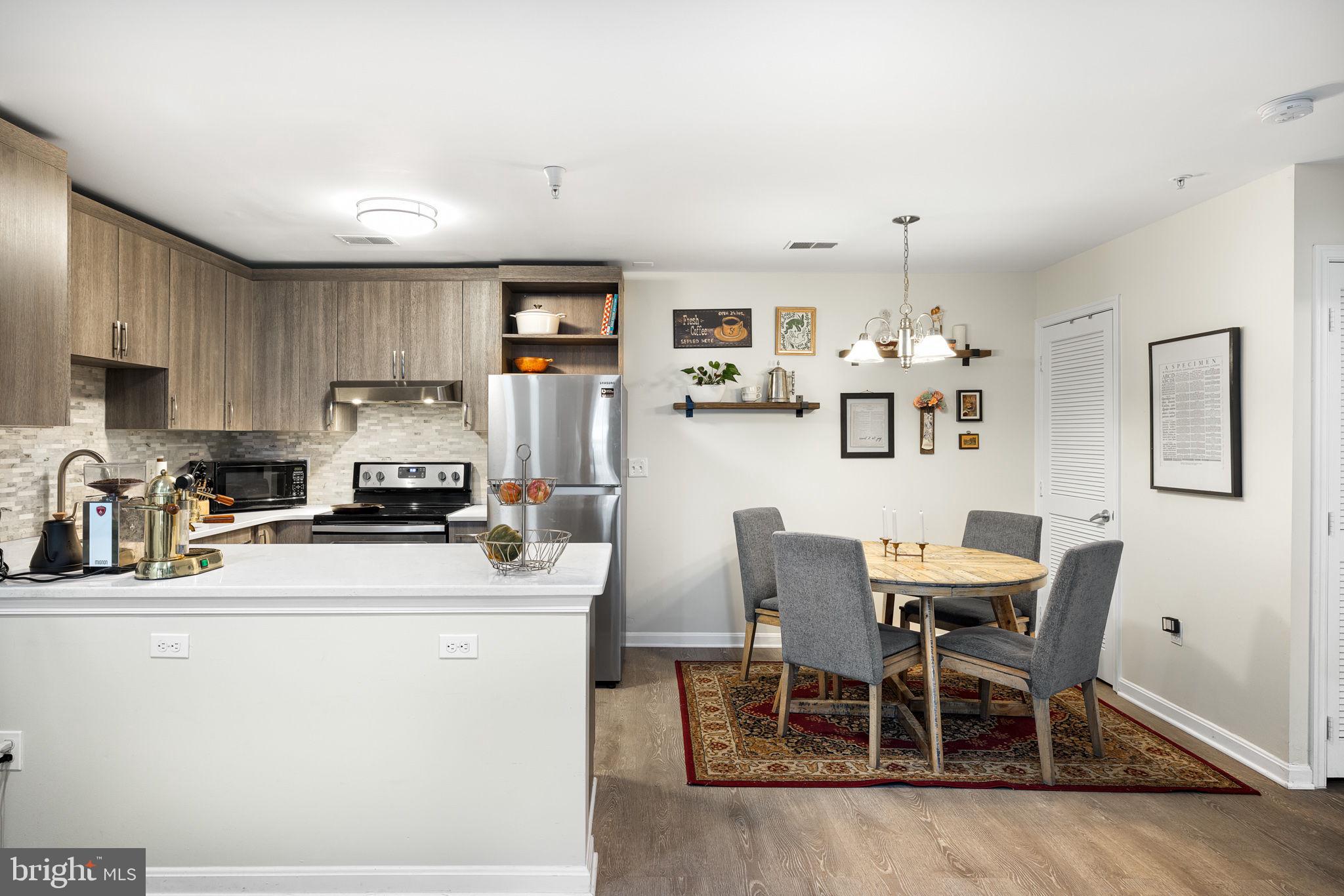 645 Constellation Square Southeast, Unit B Leesburg, VA 20175 - Photo 7 of 17 a kitchen with stainless steel appliances a dining table chairs refrigerator and sink