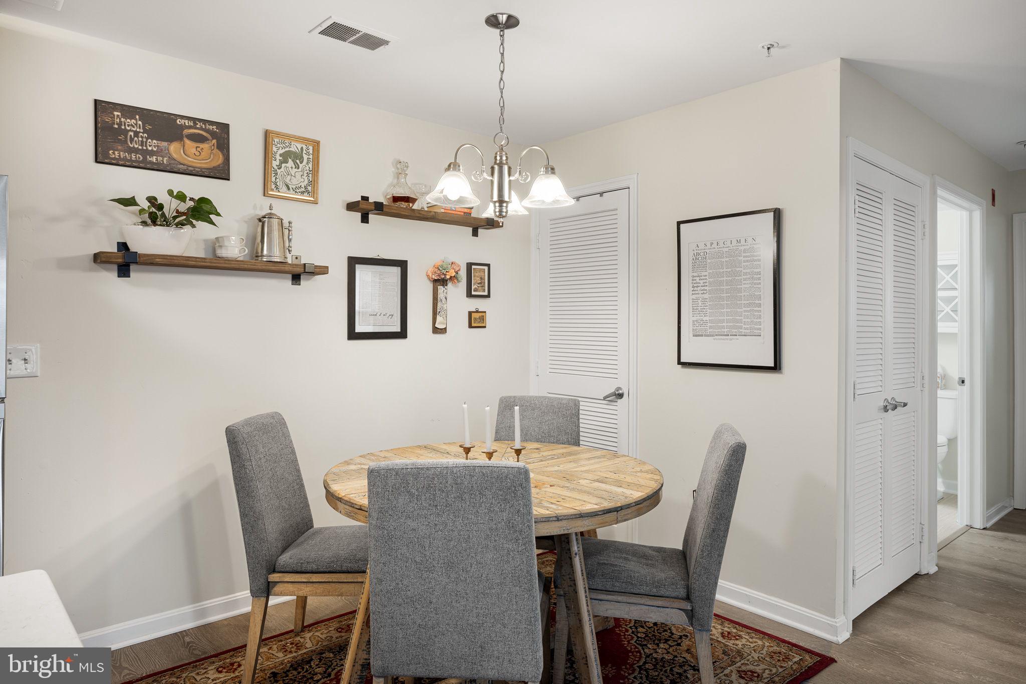 645 Constellation Square Southeast, Unit B Leesburg, VA 20175 - Photo 10 of 17 a dining room with furniture a chandelier and wooden floor