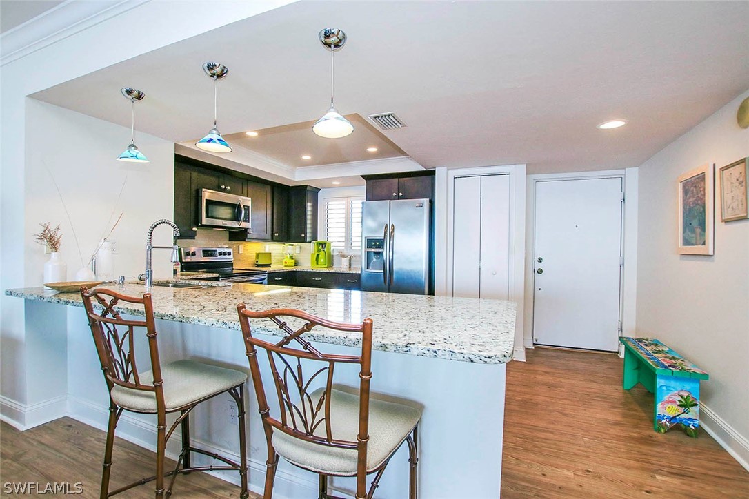 15011 Punta Rassa Road, Unit 204 Fort Myers, FL 33908 - Photo 8 of 23 a dining room with furniture and wooden floor
