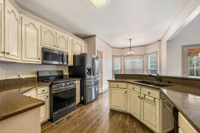 a kitchen with stainless steel appliances granite countertop a stove a sink and a microwave