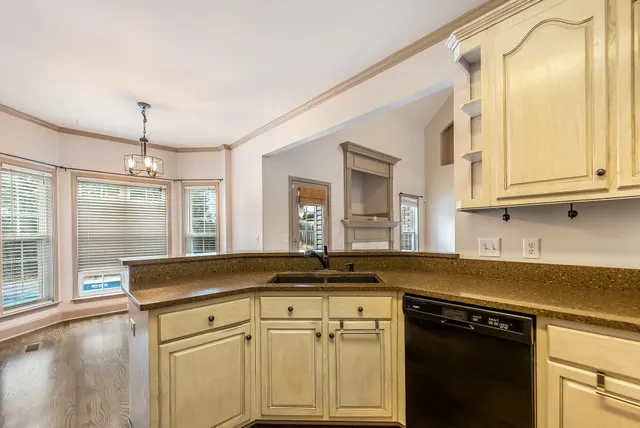 a kitchen with granite countertop a sink and white cabinets