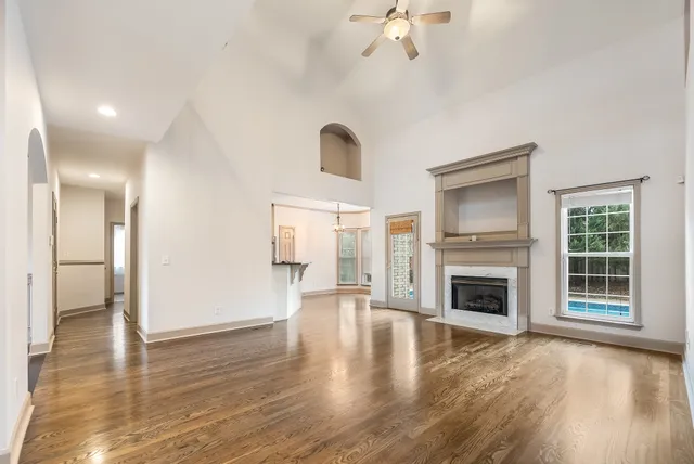 a view of empty room with a fireplace and wooden floor