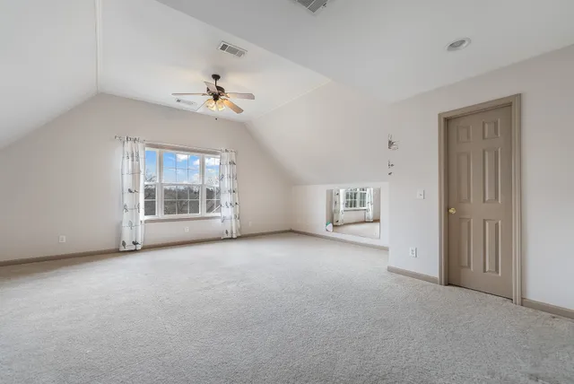 an empty room with a fireplace and windows