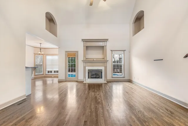 a view of a livingroom with wooden floor and a fireplace