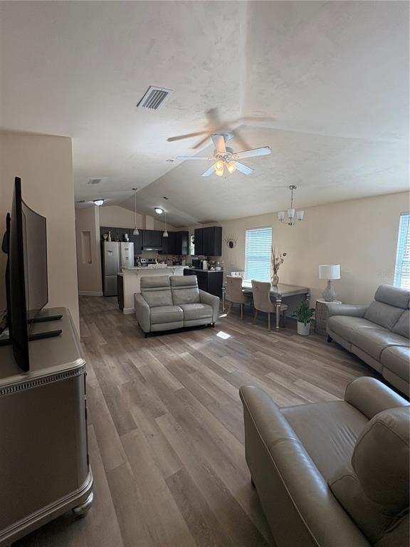 13002 Southwest 174th Street Archer, FL 32618 - Photo 2 of 10 a living room with furniture a flat screen tv and kitchen view