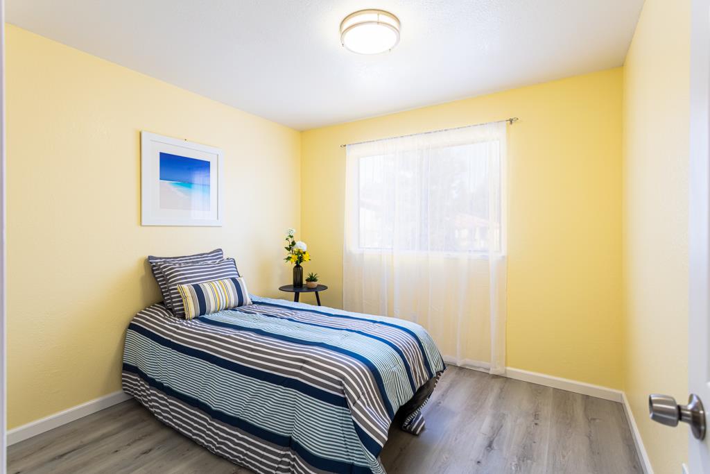 93 Shaniko Common, Unit 24 Fremont, CA 94539 - Photo 15 of 25 a bedroom with a bed and wooden floor