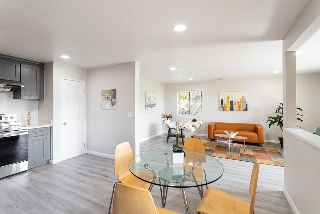 93 Shaniko Common, Unit 24 Fremont, CA 94539 - Photo 8 of 25 a living room with furniture kitchen view and a wooden floor